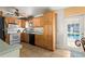 Functional kitchen with wooden cabinets, white appliances, and a door leading to the pool area at 8430 Pamlico St, Orlando, FL 32817