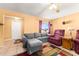 Cozy living room with grey couch, purple recliner, colorful rug and tile flooring at 8430 Pamlico St, Orlando, FL 32817