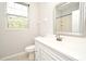 Bright bathroom features a vanity with a framed mirror and white cabinets at 8775 Sartori St # 208, Orlando, FL 32829