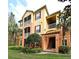 Inviting exterior of the building featuring well-maintained lawns and multiple stories with screened in patios at 8775 Sartori St # 208, Orlando, FL 32829