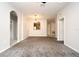 Spacious living room featuring neutral paint, gray carpet, and arched doorways at 8775 Sartori St # 208, Orlando, FL 32829