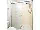 The shower has sliding frosted-glass doors, and an adjustable shower head in this condo bathroom at 8775 Sartori St # 208, Orlando, FL 32829