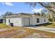 Side view of a white house featuring a one-car garage and an air conditioning unit outside at 901 S Holly Ave, Sanford, FL 32771