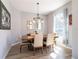 Elegant dining room featuring a stylish chandelier, modern table set, and natural light at 10688 Sw 129Th Terrace Rd, Dunnellon, FL 34432