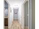 Well-lit hallway featuring wood floors and doors leading to various rooms at 10688 Sw 129Th Terrace Rd, Dunnellon, FL 34432