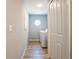 Hallway view of a laundry room with a washer, dryer, and an octagonal window at 10688 Sw 129Th Terrace Rd, Dunnellon, FL 34432
