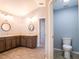 Bathroom with dual sinks, wood cabinets, and a separate toilet area at 10688 Sw 129Th Terrace Rd, Dunnellon, FL 34432