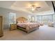 Spacious main bedroom with tray ceiling, ceiling fan, large windows, and neutral decor at 10688 Sw 129Th Terrace Rd, Dunnellon, FL 34432
