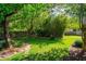 Secluded backyard featuring manicured lawn, stepping stone pathway, and ample shade at 113 Wheatland Ct, Longwood, FL 32779