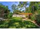 Spacious backyard with a shade sail over a seating area, lush landscaping, and a privacy fence at 113 Wheatland Ct, Longwood, FL 32779