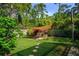 Serene backyard with a shade structure, lounge seating, and lush greenery, creating a private retreat at 113 Wheatland Ct, Longwood, FL 32779