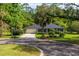 Charming single-story home with a well-manicured lawn, mature trees, and a winding driveway at 113 Wheatland Ct, Longwood, FL 32779