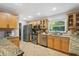 Well-lit kitchen with stainless steel appliances, granite countertops, and tile backsplash at 113 Wheatland Ct, Longwood, FL 32779