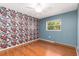 Bedroom showcasing laminate flooring and a decorative floral accent wall at 116 Cambridge Dr, Longwood, FL 32779