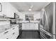 Bright kitchen featuring modern appliances, white cabinetry, black hardware and black tile floors at 116 Cambridge Dr, Longwood, FL 32779
