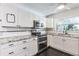 Bright kitchen featuring stainless appliances, granite counters, white cabinets and black tile floors at 116 Cambridge Dr, Longwood, FL 32779