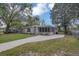 Quaint home featuring a screened-in porch, freshly manicured lawn and a paved driveway at 119 Mayfair Cir, Sanford, FL 32771