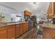 Open-concept kitchen features wood cabinets, granite countertops, stainless steel appliances, and adjacent living area at 119 Mayfair Cir, Sanford, FL 32771