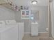 Functional laundry area includes washer, dryer, storage shelves, and sink at 119 Mayfair Cir, Sanford, FL 32771