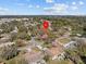 Aerial view of the property highlighted by a red pin, set in a neighborhood full of mature trees at 1228 Walker S Cir, Lakeland, FL 33805