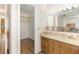 Bathroom featuring wood cabinets, a large mirror, and a walk-in closet at 1417 High Point Blvd # 150D, Orlando, FL 32825