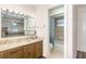 Bathroom featuring wood cabinets, a large mirror, and a shower-tub combo with patterned curtain at 1417 High Point Blvd # 150D, Orlando, FL 32825