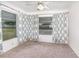 Cozy carpeted room featuring light walls, curtains, two large windows, and a ceiling fan at 1417 High Point Blvd # 150D, Orlando, FL 32825