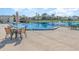 Community Pool with lounge chairs, tables, umbrellas and view of the lake with a fountain at 1417 High Point Blvd # 150D, Orlando, FL 32825