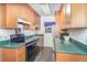 Efficient kitchen features wood cabinets, green countertops, stainless steel refrigerator, and black appliances at 1417 High Point Blvd # 150D, Orlando, FL 32825
