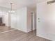 Neutral living room with wood-look floors, large mirror, chandelier and hallway at 1417 High Point Blvd # 150D, Orlando, FL 32825