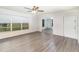 Bright living room featuring wood-look flooring, a ceiling fan, and large windows for natural light at 1417 High Point Blvd # 150D, Orlando, FL 32825