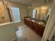 Bathroom featuring a tile shower and dual sinks with granite countertops at 15198 Harrington Cove Dr, Orlando, FL 32824
