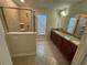 Bathroom featuring a tile shower and dual sinks with granite countertops at 15198 Harrington Cove Dr, Orlando, FL 32824