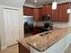 Modern kitchen with stainless steel appliances, granite countertops, and ample cabinet space at 15198 Harrington Cove Dr, Orlando, FL 32824