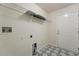 Bright laundry room features geometric tile flooring, wire shelving, and utility connections at 1600 Amboy Dr, Deltona, FL 32738