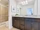 Bathroom featuring a granite countertop, dual sinks, and a glass-enclosed shower with tiled walls at 1602 Lima Ave, Kissimmee, FL 34747