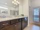 A bathroom with granite double vanity, recessed lights and an exterior access door offer convenience and style at 1602 Lima Ave, Kissimmee, FL 34747