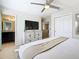 Bedroom featuring a stylish bed, fan, and connecting bathroom with a decorative dresser at 1602 Lima Ave, Kissimmee, FL 34747