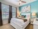 Bedroom featuring a stylish bed, windows with curtains, and teal decor accents with ample natural light at 1602 Lima Ave, Kissimmee, FL 34747
