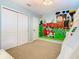 Whimsical bedroom with custom mural, closet, and neutral carpeting at 1602 Lima Ave, Kissimmee, FL 34747