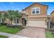 Charming two-story home featuring a brick driveway, attached two car garage and tropical landscaping at 1602 Lima Ave, Kissimmee, FL 34747