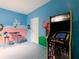 Fun game room featuring colorful murals, a multi-arcade game, and a table with bar stools at 1602 Lima Ave, Kissimmee, FL 34747
