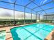 Screened in backyard pool with pristine blue water and brick trim, great for entertaining and relaxing at 1602 Lima Ave, Kissimmee, FL 34747