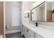 Well-lit bathroom featuring a vanity with marble countertop and black hardware, a framed mirror, and shower at 1621 Crescent Rd, Longwood, FL 32750