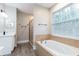 Bright bathroom featuring a soaking tub, shower, and vanity with modern fixtures, and wood-look tile floors at 1621 Crescent Rd, Longwood, FL 32750