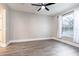 Neutral bedroom boasts wood-look tile floors, a ceiling fan, and a window with trim, creating a relaxing atmosphere at 1621 Crescent Rd, Longwood, FL 32750