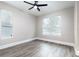 Spacious bedroom boasts wood-look tile floors, a ceiling fan, and multiple bright windows offering serene view at 1621 Crescent Rd, Longwood, FL 32750
