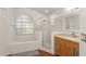 Bright bathroom with wood flooring, a large soaking tub, glass enclosed shower, and a single vanity at 16224 Magnolia Hill St, Clermont, FL 34714