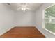 Empty bedroom features a ceiling fan, wood flooring, a window, and freshly painted white walls at 16224 Magnolia Hill St, Clermont, FL 34714