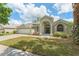 Charming single-story home featuring an arched entryway, well-manicured lawn, and a two-car garage at 16224 Magnolia Hill St, Clermont, FL 34714